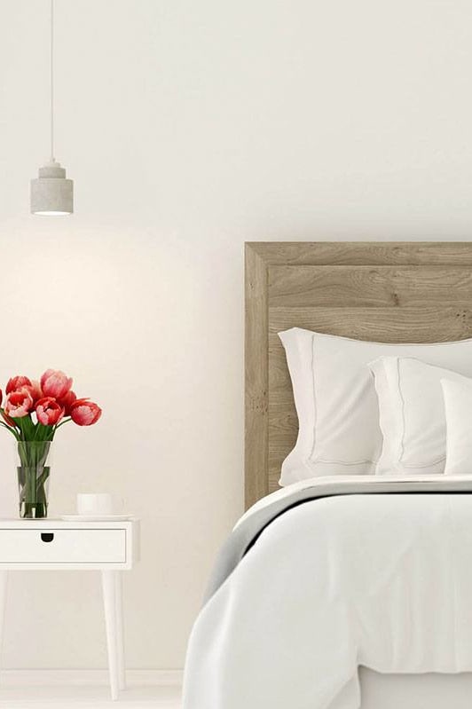 a bedroom with a bed and a vase of flowers