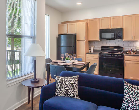 a living room with a kitchen and a balcony