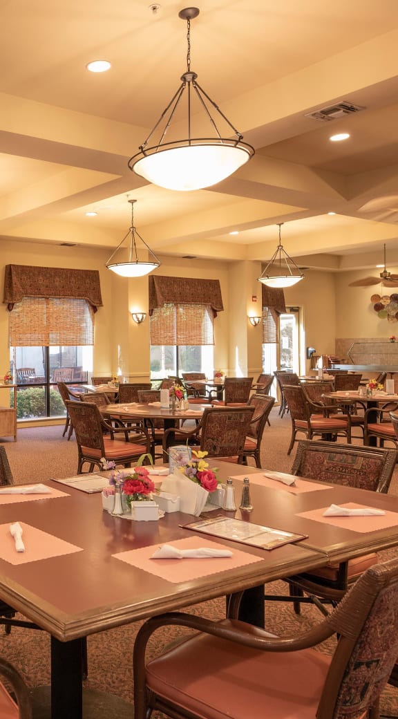 a large dining room with tables and chairs and windows at Winding Commons Senior Living, Carmichael, CA, 95608