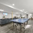 a games room with a ping pong table and a tv