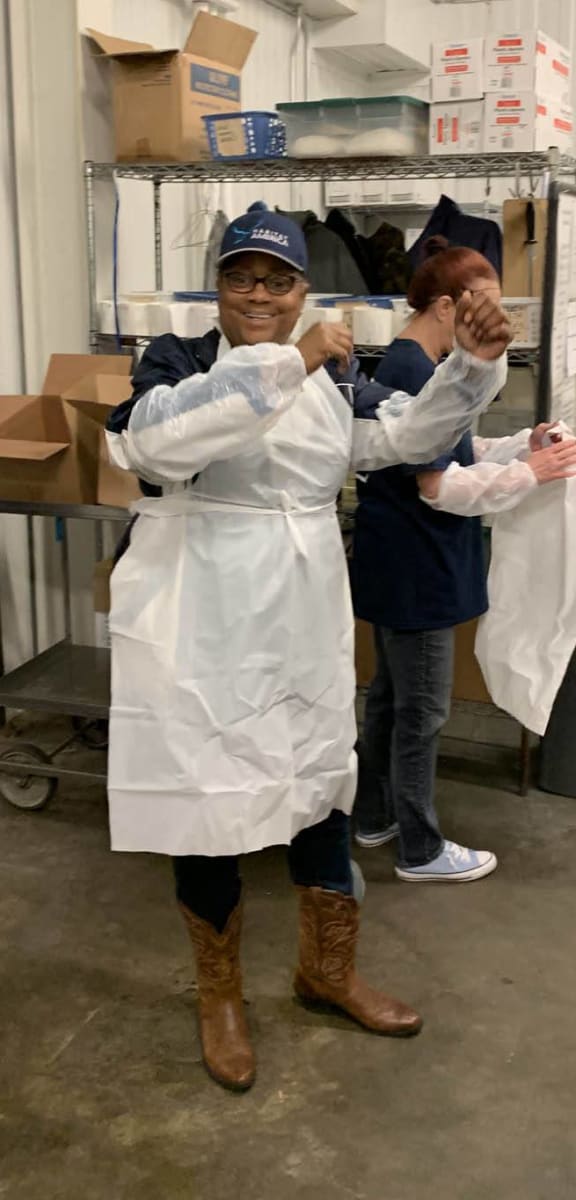 a group of chefs standing in a kitchen holding up their hands