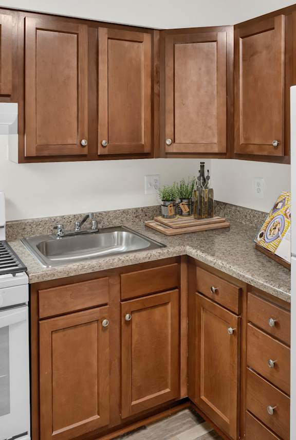 a kitchen with white appliances and brown cabinets and a refrigerator