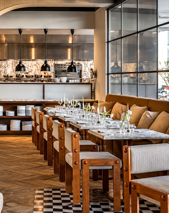 A restaurant with a long table set for a meal.