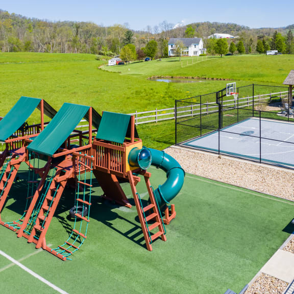 an aerial view of a playground with slides and a tennis court