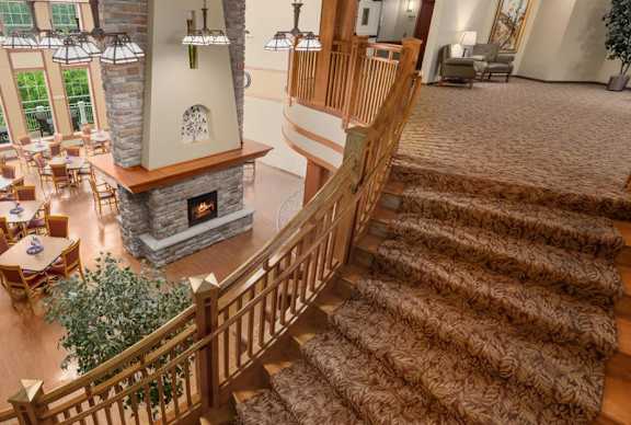 A large, well-lit living room with a staircase leading to the upper floor.