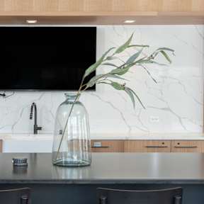 A kitchen with a marble countertop and white cabinets.