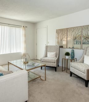 River Pointe model apartment living room with chairs, coffee table, couch, and wall art