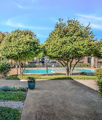 A backyard with a pool and a small garden.