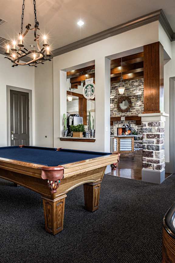 a game room with a pool table and a door to a bar
