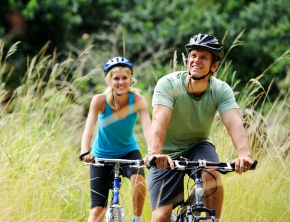 Man and Woman Smiling while Biking Together