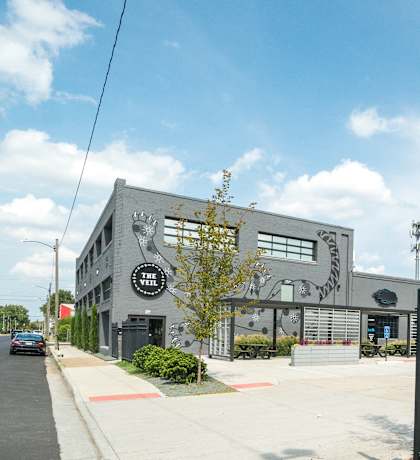a large building with a black fence and a street with cars
