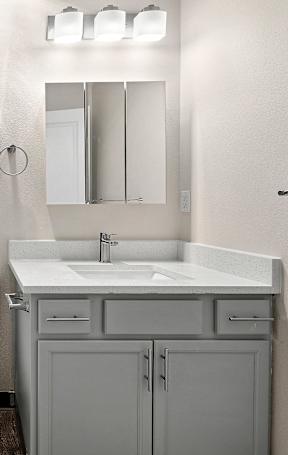 A renovated bathroom with a sink and storage.