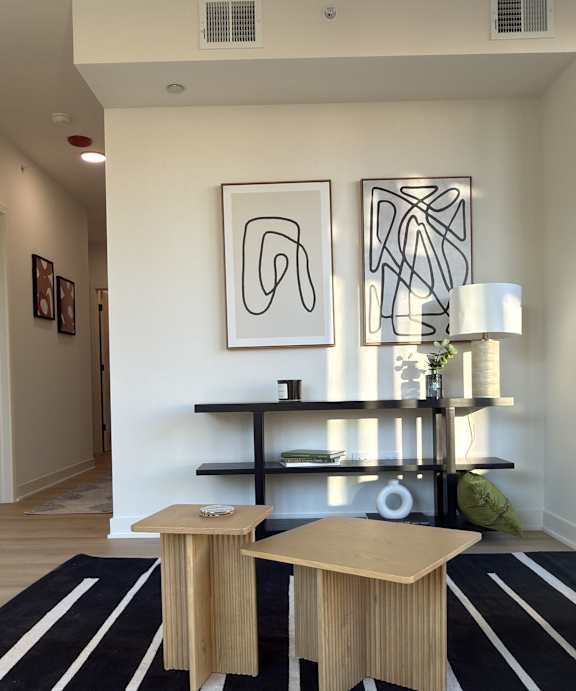 A modern living room with a grey sofa, a white coffee table, and a large window.