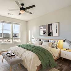 A bedroom with a bed, chair, and window.