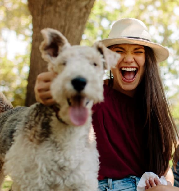 a group of friends sitting in the park with a dog