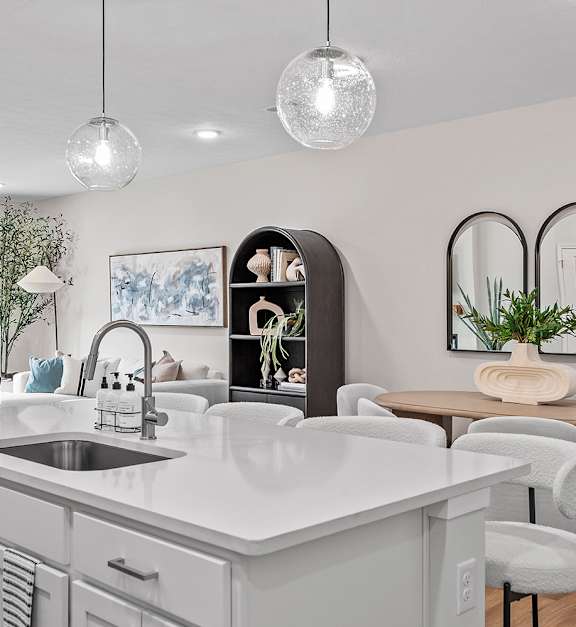 A modern kitchen with a large island and a dining area.