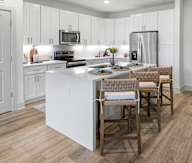 A kitchen with a white island and wooden floors in Santa Rosa Beach, FL
