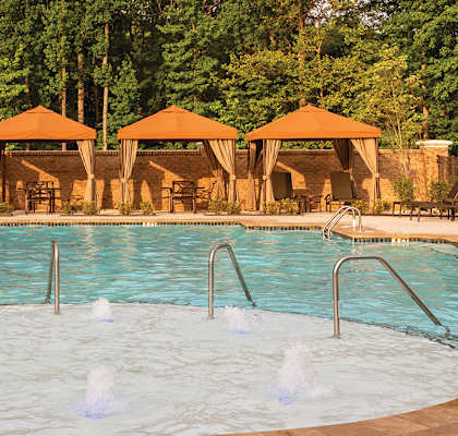 Pool With Cabanas and Chairs