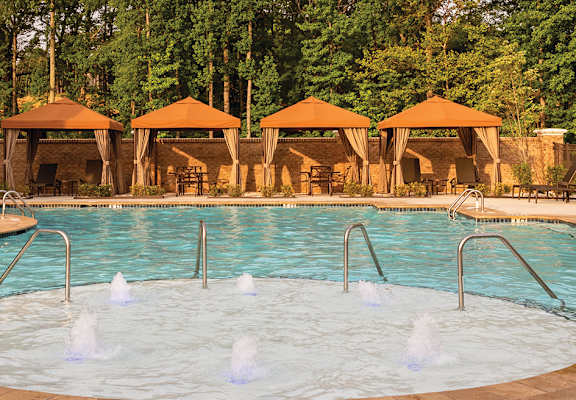 Pool With Cabanas and Chairs