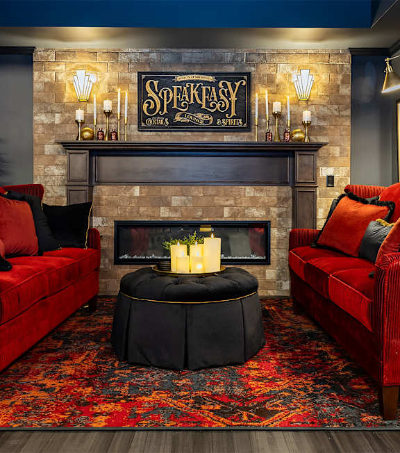 A living room with red couches and a fireplace.
