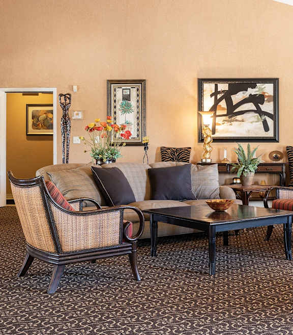 A cozy clubhouse living room at Cedar Crest Apartments featuring plush seating, a warm fireplace, and inviting decor.
