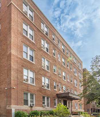 a large brick building with a sidewalk in front of it