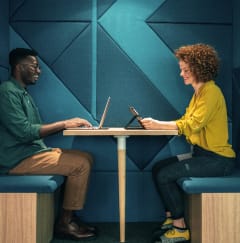 a man and a woman sitting at a table with laptops at North Grove, Riverside California