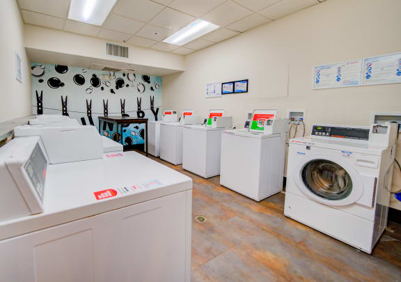 a laundry room filled with washers and dryers and a row of washing machines at The Vine on 8th, Las Vegas
