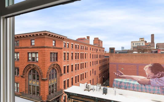 A woman is painting a picture on a canvas on a balcony.