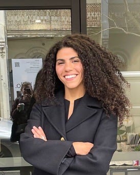 a woman standing in front of a door with her arms crossed