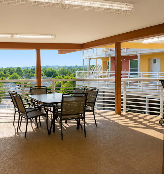 A dining table with chairs is in a room with yellow walls and a view of the outdoors.