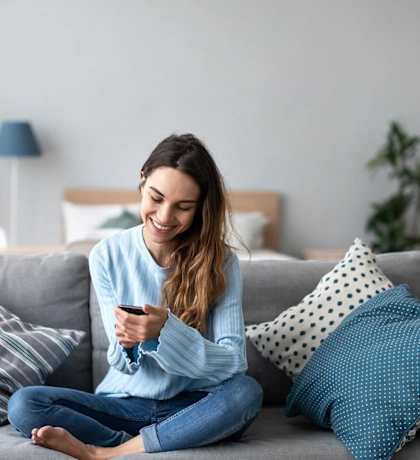 Woman on couch looking at smartphone