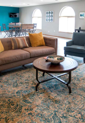 a living room with a brown couch and two black chairs