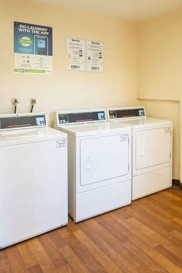 a laundry room with four washes and dryers in it