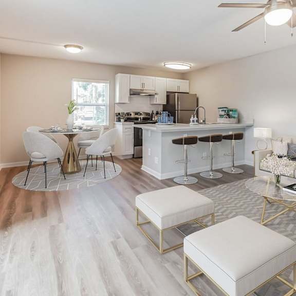 A modern living room with a kitchen in the background.