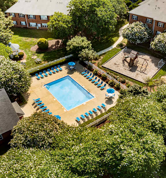 an aerial view of a pool in the backyard of a house