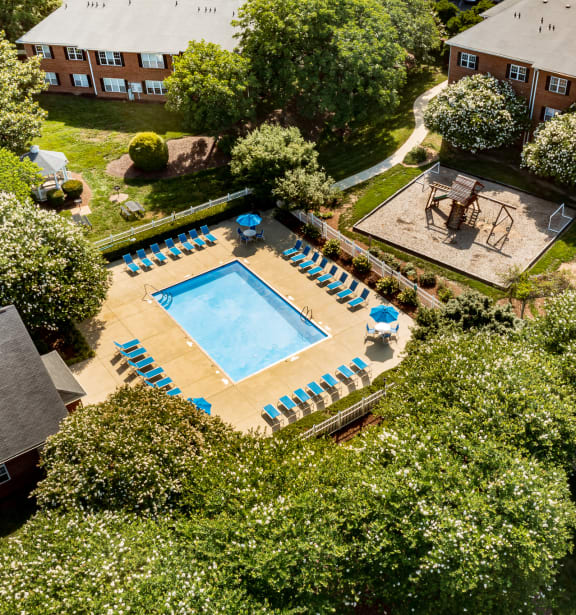 an aerial view of a pool in the backyard of a house