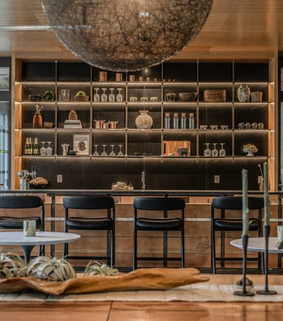A modern dining area with a wooden table and black chairs.