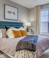 A bedroom with a bed, nightstand, and window.