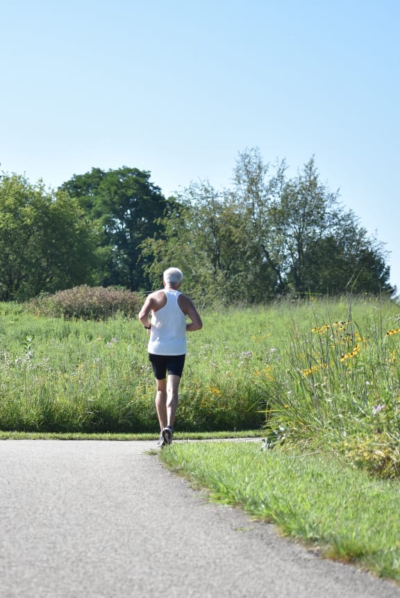 a woman running down a path in a field