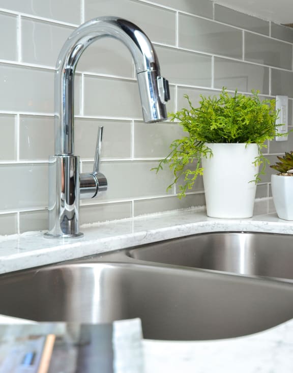 a kitchen sink with a chrome faucet in a kitchen at Apartments at Denver Place, Denver, CO