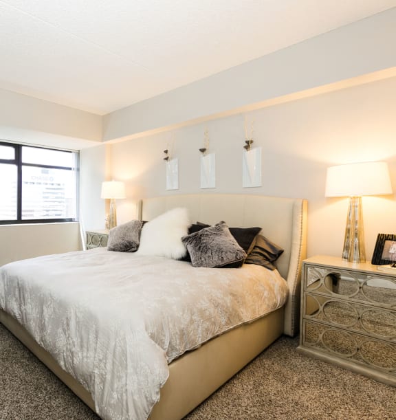 a bedroom with a large bed and a large window at Apartments at Denver Place, Denver