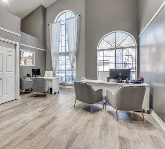 an office with a desk with a printer and a table with chairs at Foxborough Apartments, Irving, TX