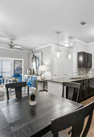 A kitchen with black cabinets and a black stove top oven.