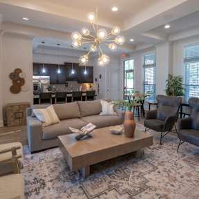 A living room with a large couch, a coffee table, and a chandelier. at Hall Creek Apartment Homes, Arlington, Tennessee