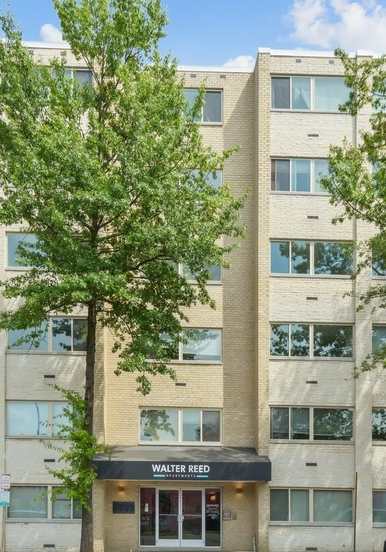 a large apartment building with a parking lot in front of it