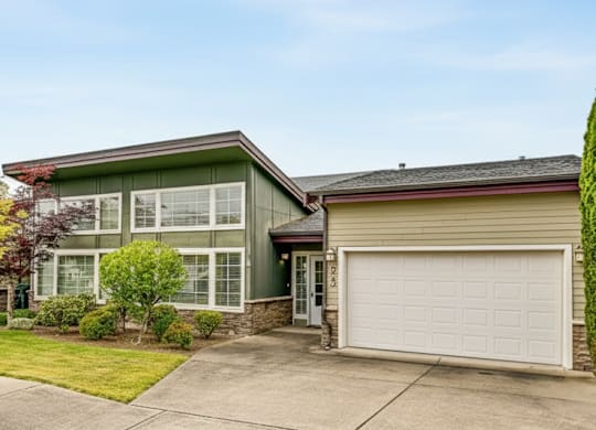 A house with a green roof and a white garage door.
