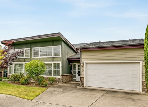 A house with a green roof and a white garage door.