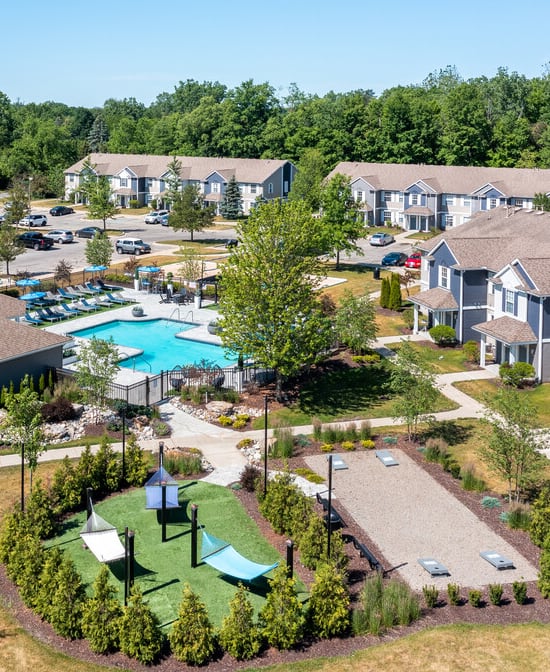 An aerial view of a swimming pool surrounded by lounge chairs and umbrellas.