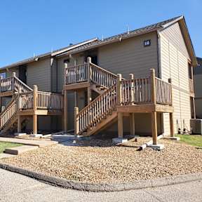 Willow Creek Apartments - A view of the apartment complex with green landscaping and walking paths.